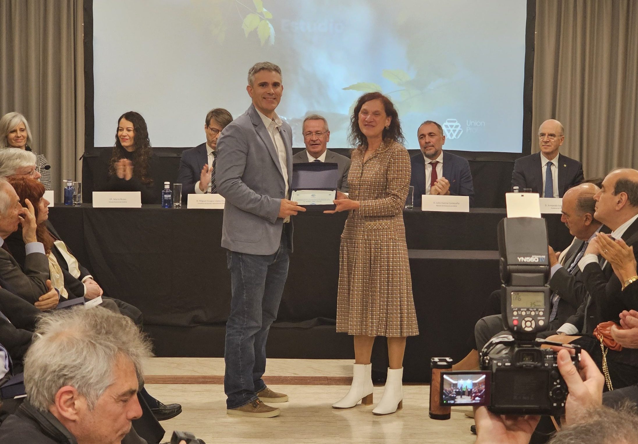 Rubén Villar recibe o premio á excelencia e ao compromiso profesional de mans da decana do COPG, Mª Rosa Álvarez Prada